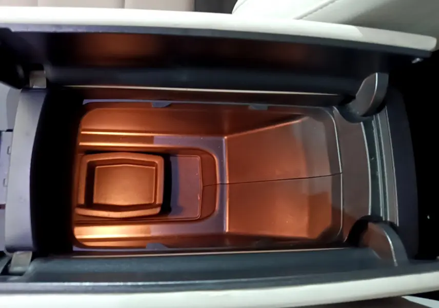 Vue plongeante sur le rangement réfrigéré noir dans l'accoudoir central du Citroën C5 Aircross Hybrid 225 ë-EAT8 Shine.