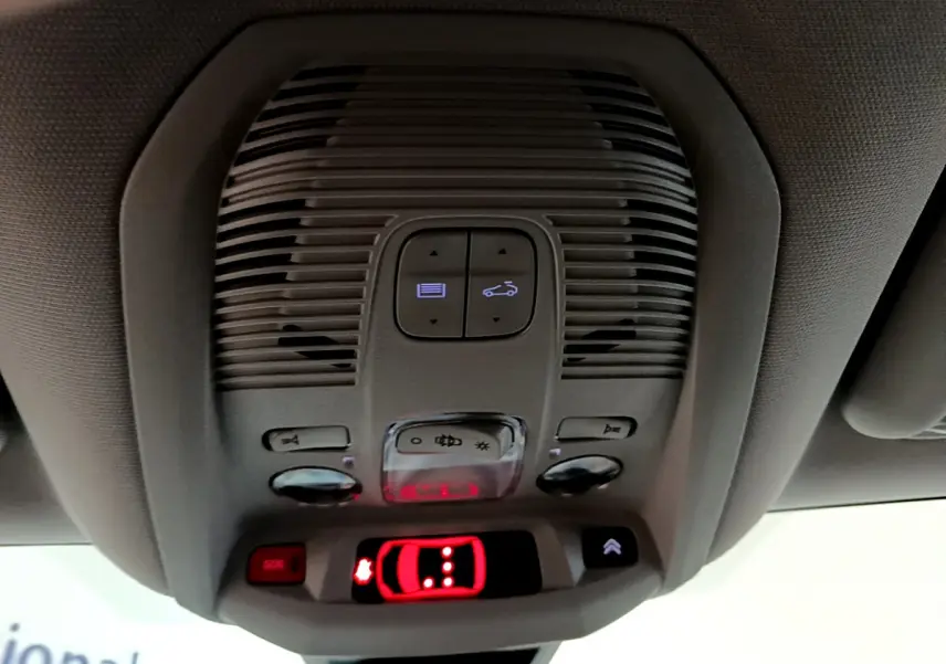 Vue en gros plan du plafonnier intérieur du Citroën C5 Aircross Hybrid 225 ë-EAT8 Shine avec commandes lumineuses et bouton SOS rouge.
