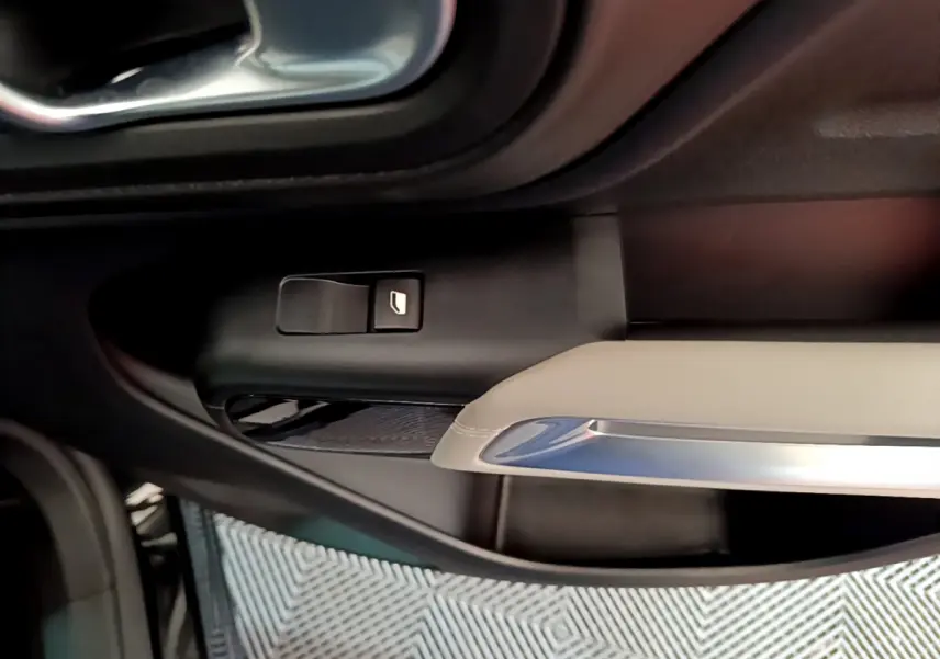 Détail de la commande de lève-vitre côté conducteur dans l'intérieur noir et beige du Citroën C5 Aircross Hybrid 225 ë-EAT8 Shine 2021.