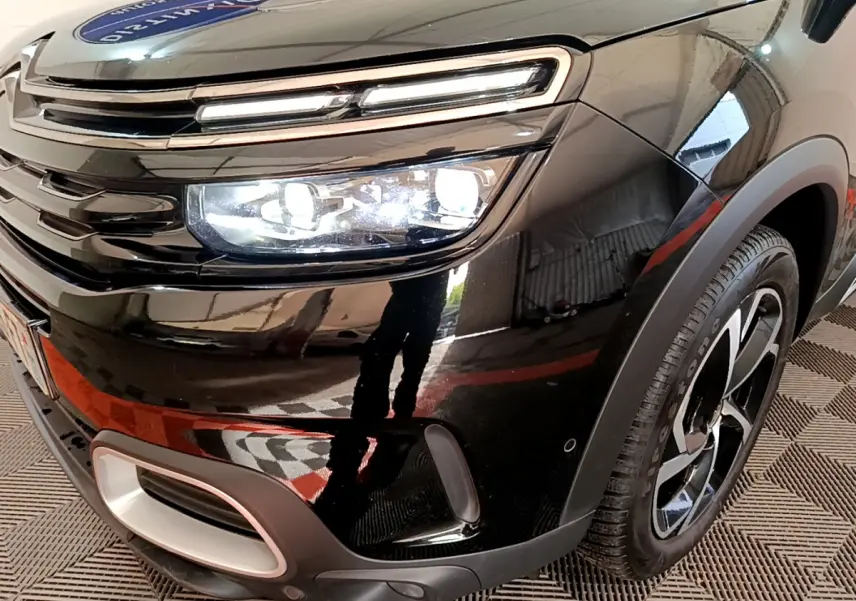 Gros plan sur l'avant droit noir brillant du Citroën C5 Aircross Hybrid avec phares LED et jante stylisée.