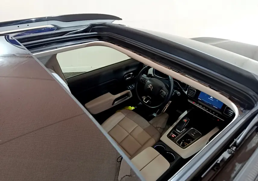 Vue plongeante sur l'intérieur beige et noir du Citroën C5 Aircross Hybrid 225 avec toit ouvrant panoramique.