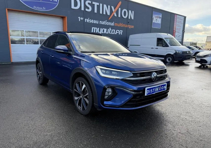 Volkswagen Taigo bleu récif métallisé en 3/4 avant droit avec jantes alliage noires brillantes et calandre R-Line.
