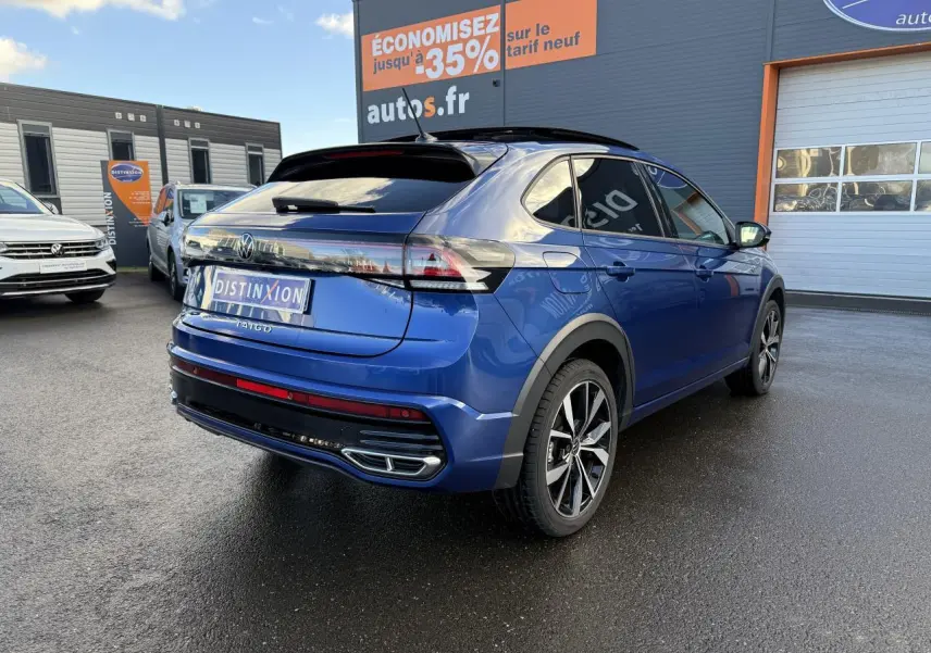 Volkswagen Taigo bleu récif métallisé en 3/4 arrière droit avec jantes noires brillantes et toit ouvrant en verre