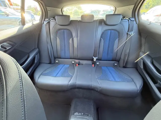 Vue intérieure arrière de la banquette en cuir noir et tissu bleu de la BMW Série 1 118d Edition Sport 2024.