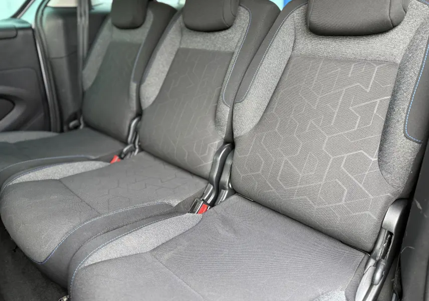 Vue rapprochée des sièges arrière en tissu gris avec surpiqûres bleues du Peugeot Partner Tepee 2018.