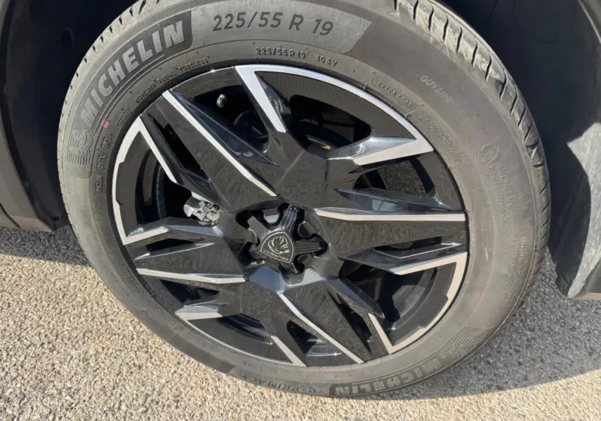 Gros plan sur la jante alliage noire et argentée de 19 pouces du Peugeot 3008 Hybrid 145 e-DCS6 Allure noir.