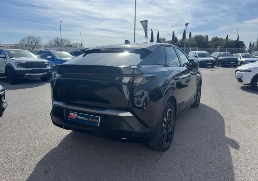 Vue 3/4 arrière droite d’un Peugeot 3008 Hybrid 145 noir avec jantes alliage 19 pouces, stationné en extérieur.