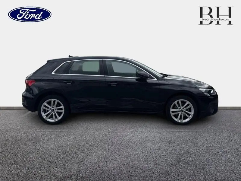 Audi A3 Sportback noir Mythic métallisé vue de profil côté gauche sur fond neutre, jantes alu visibles.