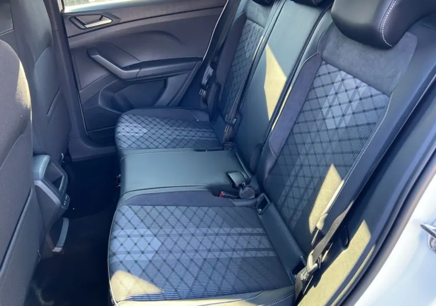 Vue intérieure côté droit sur la banquette arrière tissu gris à motifs géométriques du Volkswagen T-Cross blanc pur 2025.