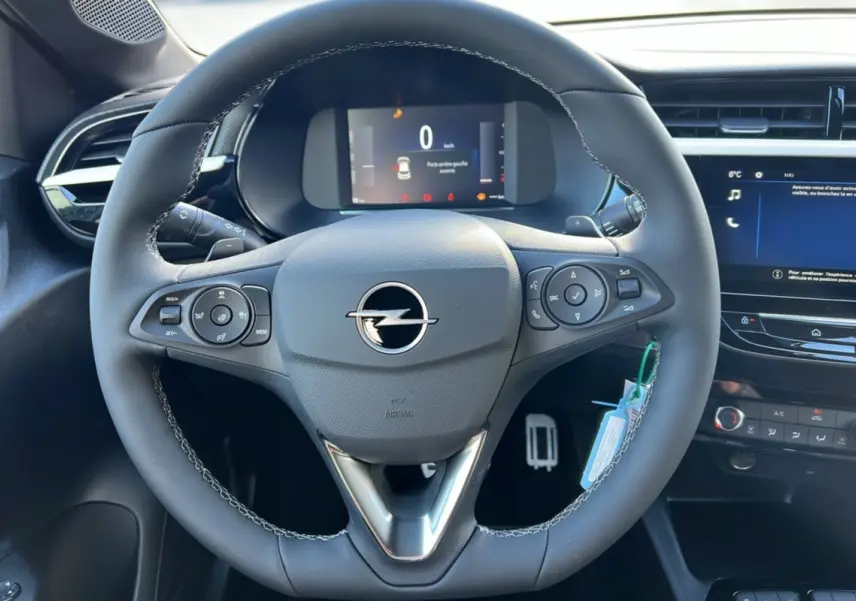 Vue rapprochée du volant cuir multifonctions de l’Opel Corsa Hybrid 110 e-DCT6, avec tableau de bord numérique et écran tactile.