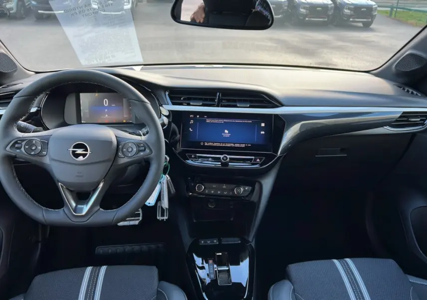 Vue intérieure avant de l’Opel Corsa Hybrid gris kristall, avec volant cuir multifonctions et écran tactile central 10 pouces.