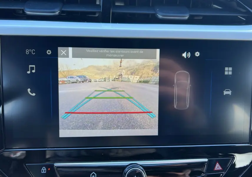 Écran tactile intérieur montrant la caméra de recul avec lignes de guidage dans une Opel Corsa Hybrid gris kristall.