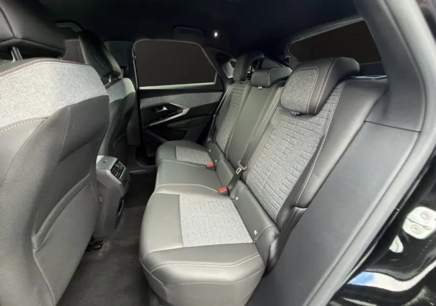 Vue intérieure arrière côté droit du Peugeot 3008 1.2 Hybrid 145 Allure, sièges bi-matière gris et noir.