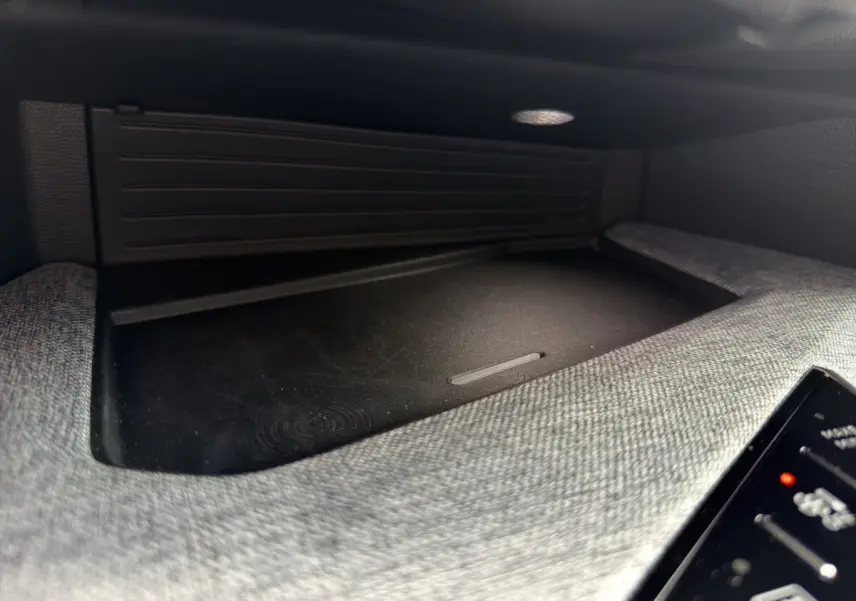 Détail intérieur du chargeur sans fil dans la console centrale du Peugeot 3008 noir 2026.