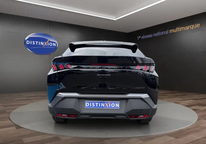 Vue arrière d’un Peugeot 3008 noir hybride 2026 avec feux LED distinctifs et toit panoramique visible en showroom.