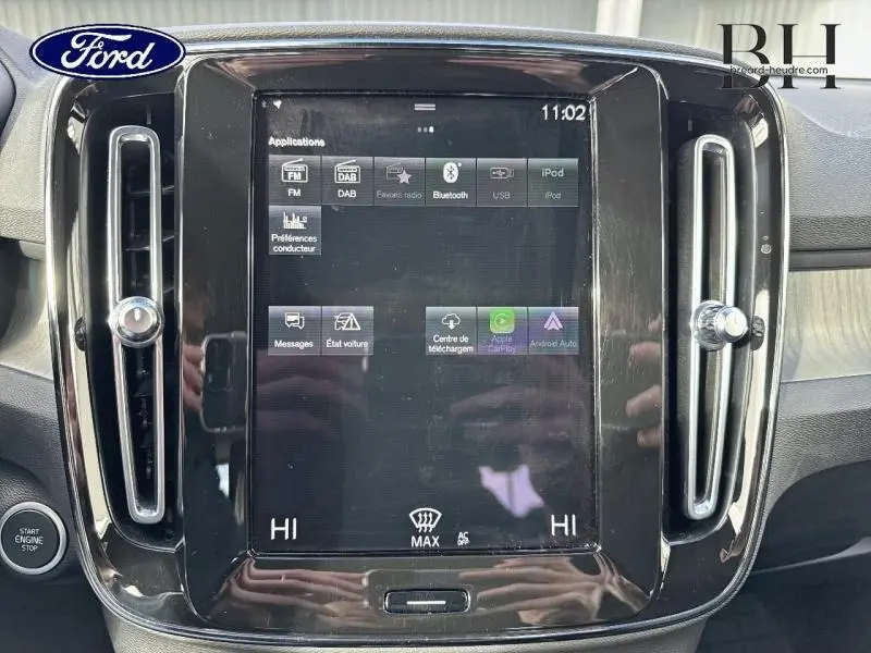 Écran tactile central du tableau de bord du Volvo XC40 bleu Denim, avec commandes climatisation et ventilation.