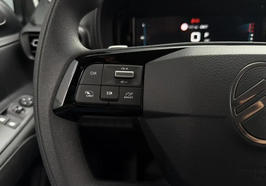 Gros plan sur le volant noir de la Citroën Berlingo 2026, avec commandes multifonctions à gauche et logo central visible.