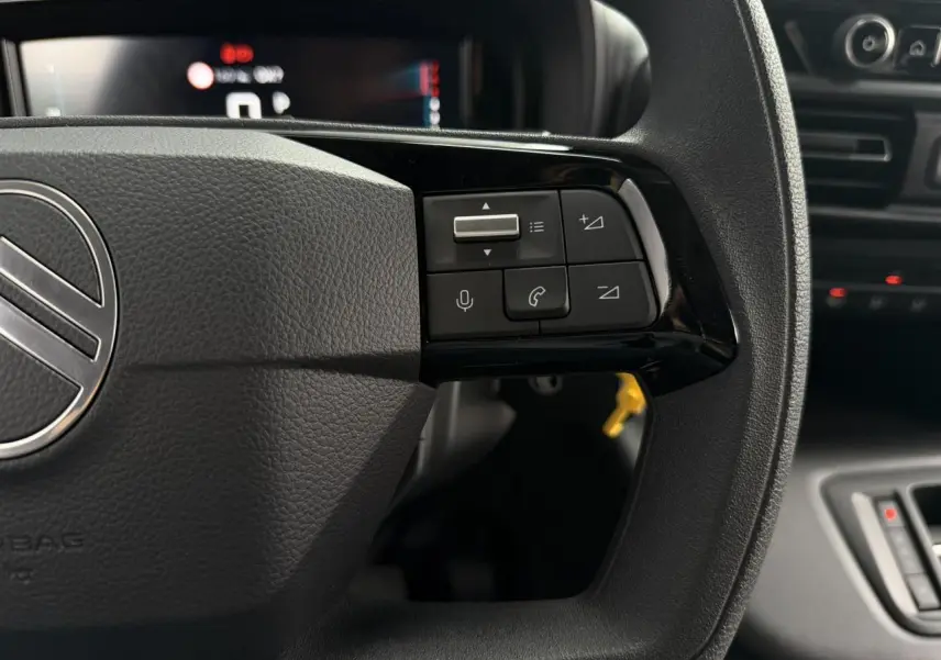 Gros plan sur la partie droite du volant multifonctions noir du Citroën Berlingo avec commandes vocales et appel.