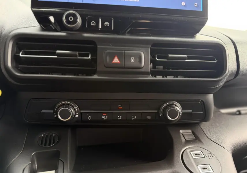 Vue rapprochée de la console centrale noire du Citroën Berlingo 2026, avec commandes climatisation et écran tactile visible.