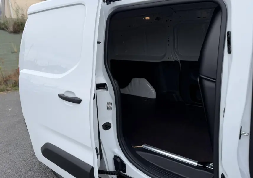 Vue de profil côté droit du Citroën Berlingo blanc Icy avec porte latérale coulissante ouverte montrant l’espace de chargement.