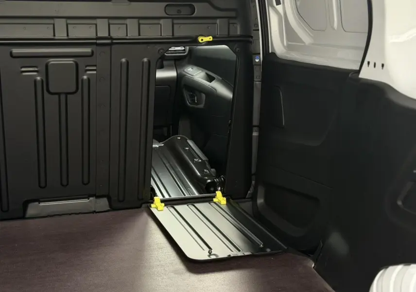 Vue intérieure du coffre côté droit du Citroën Berlingo Van XL blanc avec plancher bois antidérapant et cloison tôlée noire.