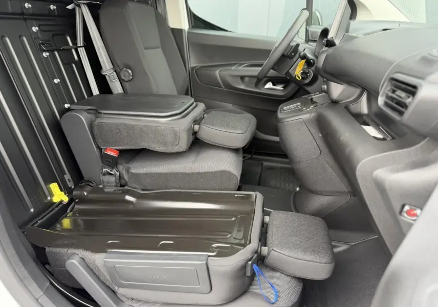 Vue intérieure côté conducteur du Citroën Berlingo Van XL 2026, sièges tissu gris avec plancher bois antidérapant.