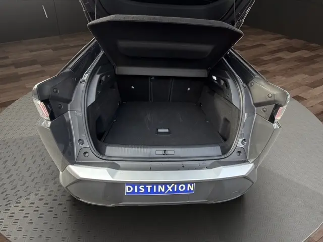 Vue arrière du coffre ouvert d’un Peugeot 3008 gris foncé, montrant l’espace de chargement vide et les feux arrière LED.