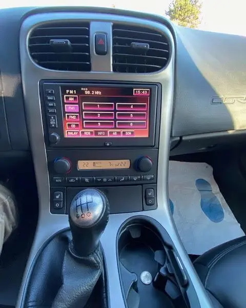 Intérieur de la Chevrolet Corvette C6 Targa 2005, vue sur la console centrale avec levier de vitesse manuel et écran radio tactile.