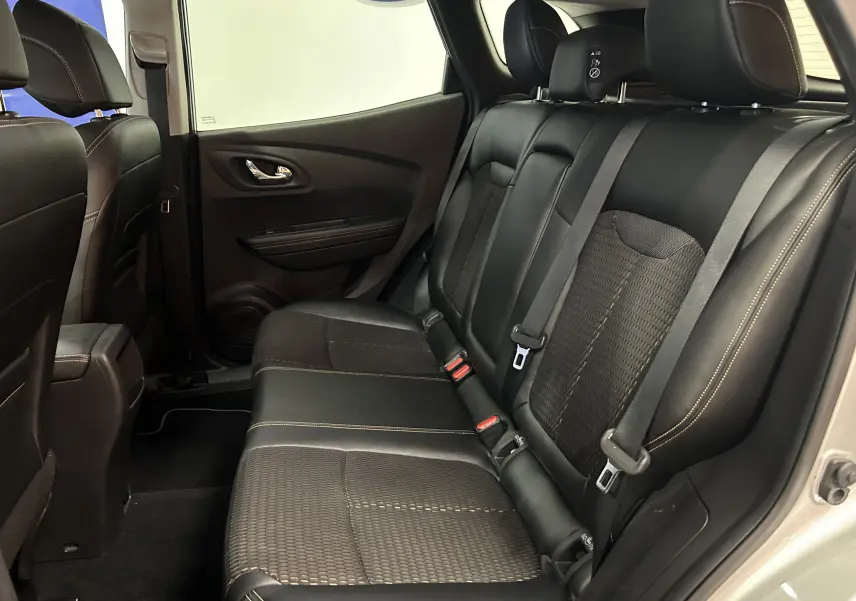 Vue intérieure arrière droite du Renault Kadjar gris 2015, sièges en tissu et cuir noir avec surpiqûres contrastées.