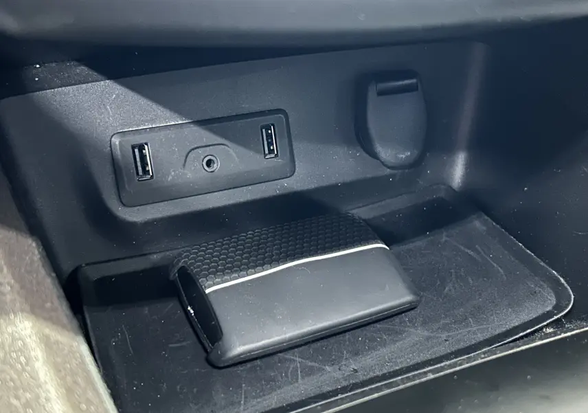 Gros plan sur la console centrale intérieure du Renault Kadjar gris, montrant ports USB et prise auxiliaire.