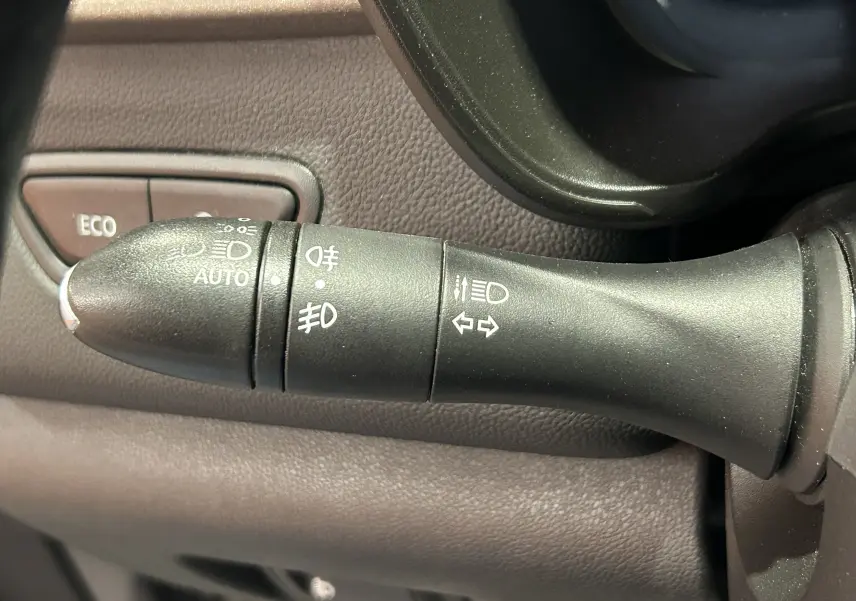 Gros plan sur la commande des feux et clignotants du Renault Kadjar gris, avec bouton ECO en arrière-plan.