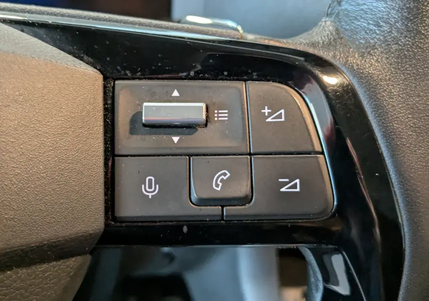 Gros plan sur les commandes vocales et téléphone au volant noir de l'Opel Vivaro Fourgon XL blanc 2024.