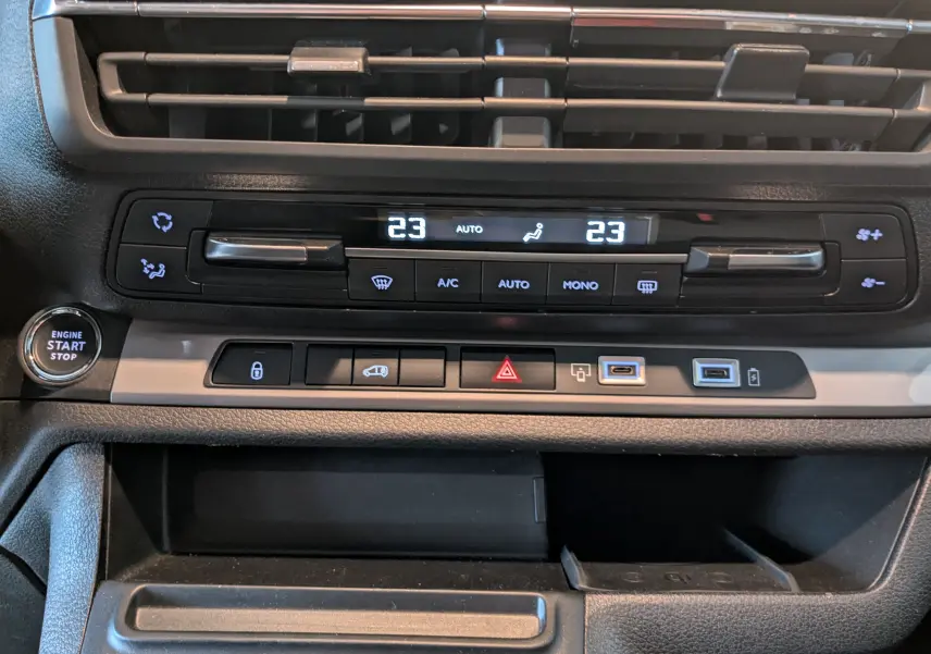 Vue rapprochée de la console centrale noire de l'Opel Vivaro Fourgon XL 2024 avec commandes climatisation et bouton start/stop.