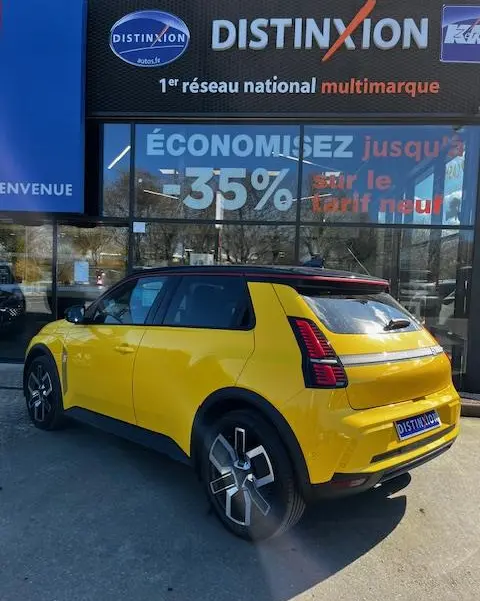 Vue 3/4 arrière droite d'une Renault R5 Techno jaune électrique 2024, avec feux arrière LED distinctifs et jantes stylisées.