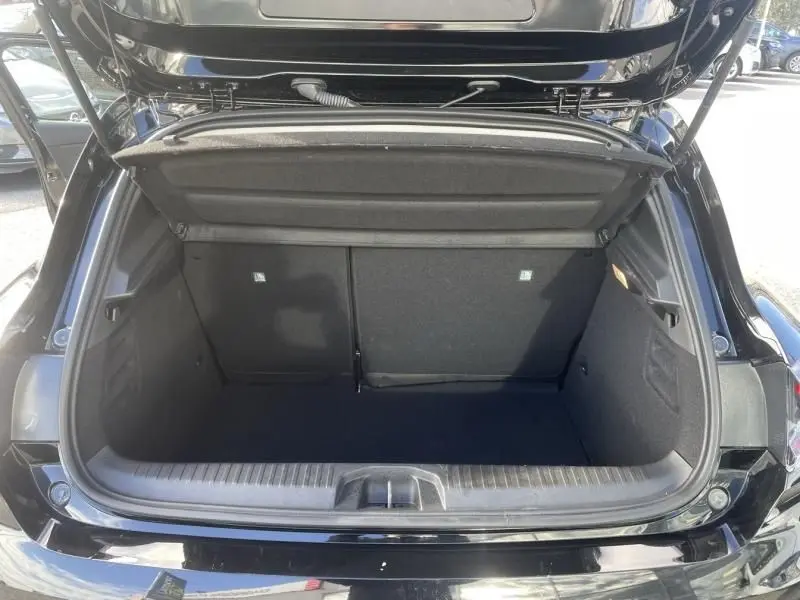 Coffre ouvert vu de l'arrière d'une Renault Clio V noire 2025, montrant l'espace de chargement vide et la tablette arrière.