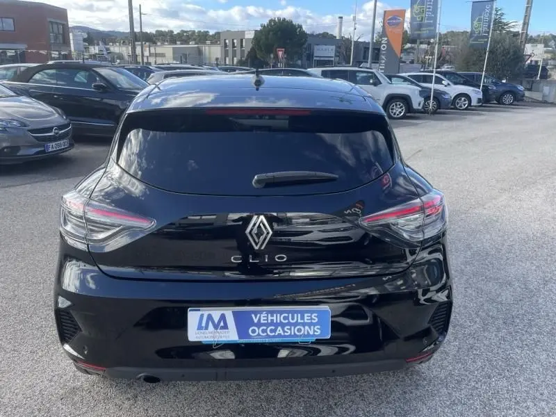 Vue arrière d'une Renault Clio V noire 2025 avec feux LED caractéristiques, sur parking extérieur d'un concessionnaire.