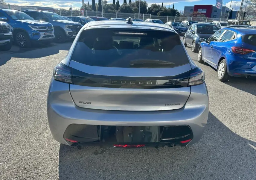 Vue arrière d'une Peugeot 208 Hybrid 110 gris métallisé, avec feux arrière noirs et logo Peugeot centré.