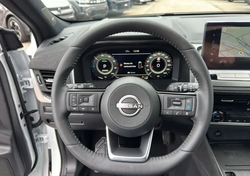 Vue centrée sur le volant cuir noir du Nissan Qashqai E-Power 205 Tekna Plus avec tableau de bord digital et écran GPS.