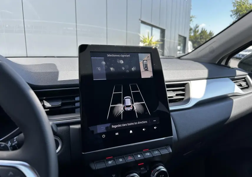 Vue intérieure du tableau de bord du Renault Captur 2024, écran tactile 9,3'' affichant l'assistance au stationnement.