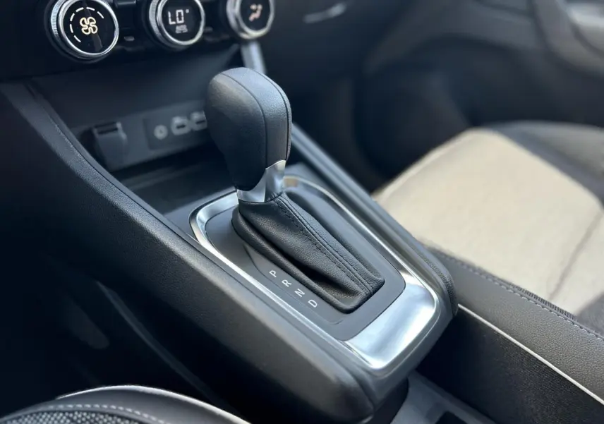 Gros plan sur la commande de la boîte automatique du Renault Captur 2024, avec sellerie claire et console noire.