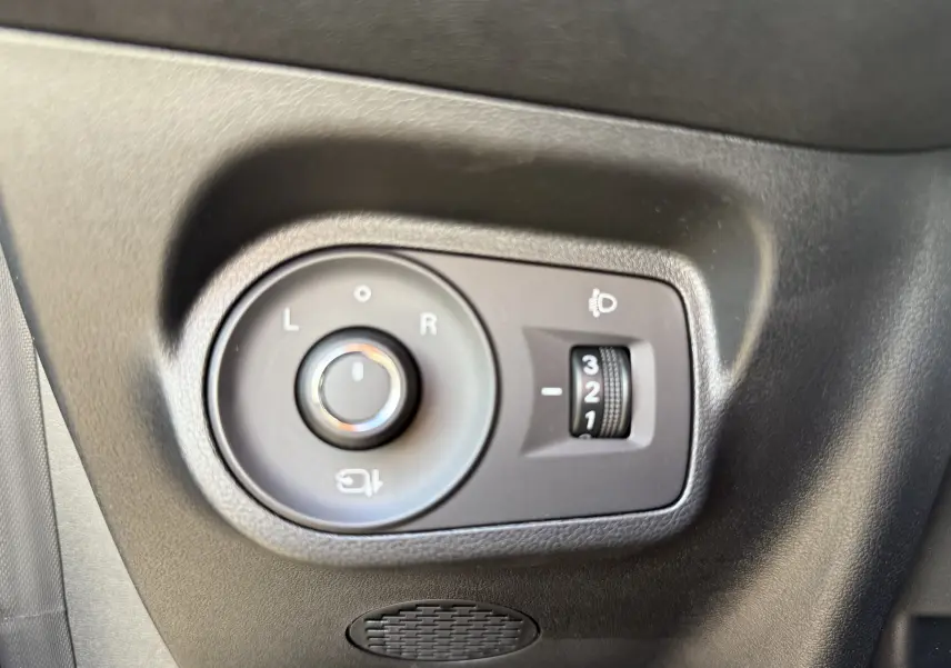 Gros plan sur les commandes de réglage des rétroviseurs et de l’éclairage, côté gauche intérieur d’une MG3 noire.