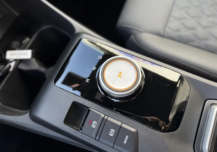 Gros plan sur la molette de sélection de la boîte automatique et les boutons de commande, intérieur noir du MG3 1.5 Hybrid+ 2026.