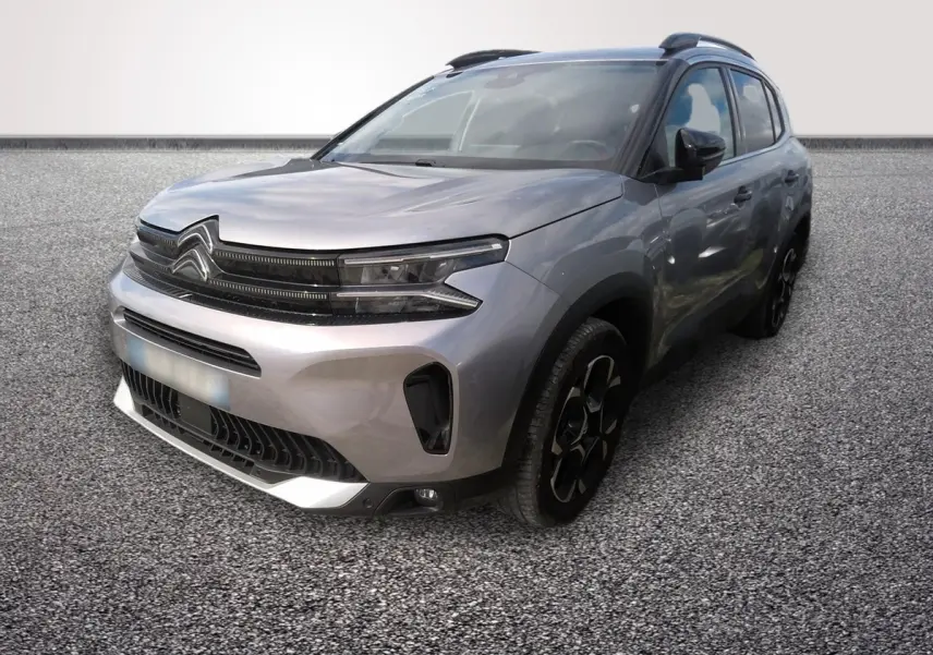 Vue 3/4 avant droit d'un Citroën C5 hybride gris clair avec calandre noire et jantes noires distinctives.