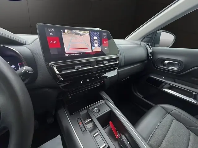 Vue intérieure côté passager du tableau de bord et console centrale noire du Citroën C5 Hybride 2024 avec écran tactile affichant la caméra de recul.