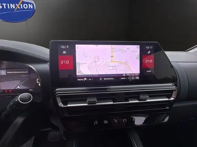 Vue rapprochée de la console centrale de la Citroën C5 Hybride 2024, écran tactile affichant la navigation et commandes climatisation.
