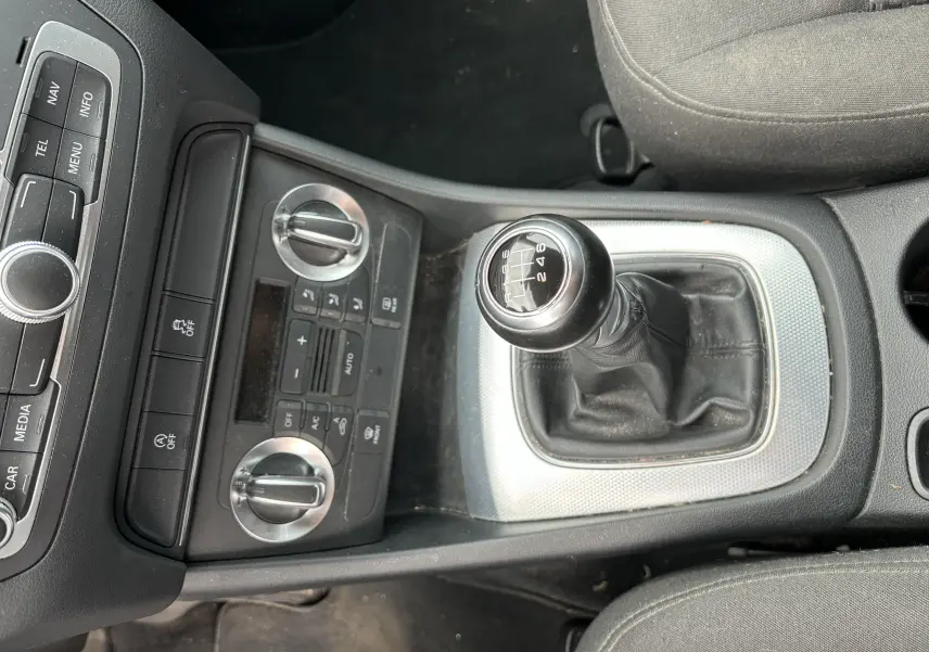 Vue plongeante sur la console centrale d'un Audi Q3 noir 2014, mettant en valeur le levier de vitesse manuel à six rapports.