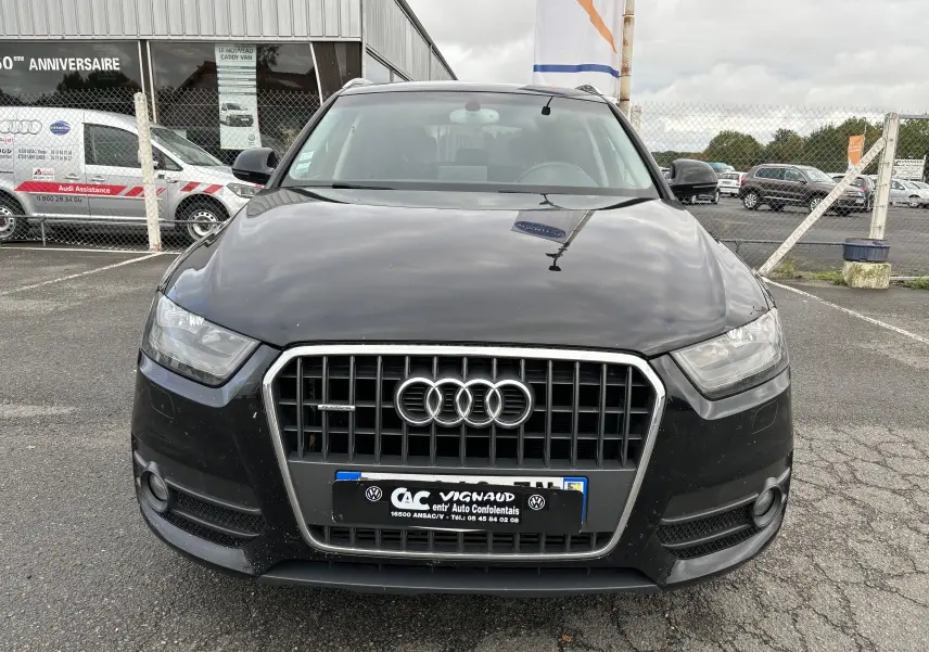 Vue frontale d'un Audi Q3 noir de 2014 avec calandre chromée et phares LED, stationné sur un parking extérieur.