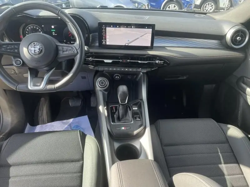 Vue intérieure avant de l'Alfa Romeo Tonale 1.3 PHEV 280 CV avec tableau de bord numérique et écran central tactile.