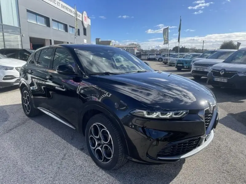 Vue 3/4 avant gauche de l'Alfa Romeo Tonale noire 2023, avec ses phares LED distinctifs et jantes à cinq cercles.