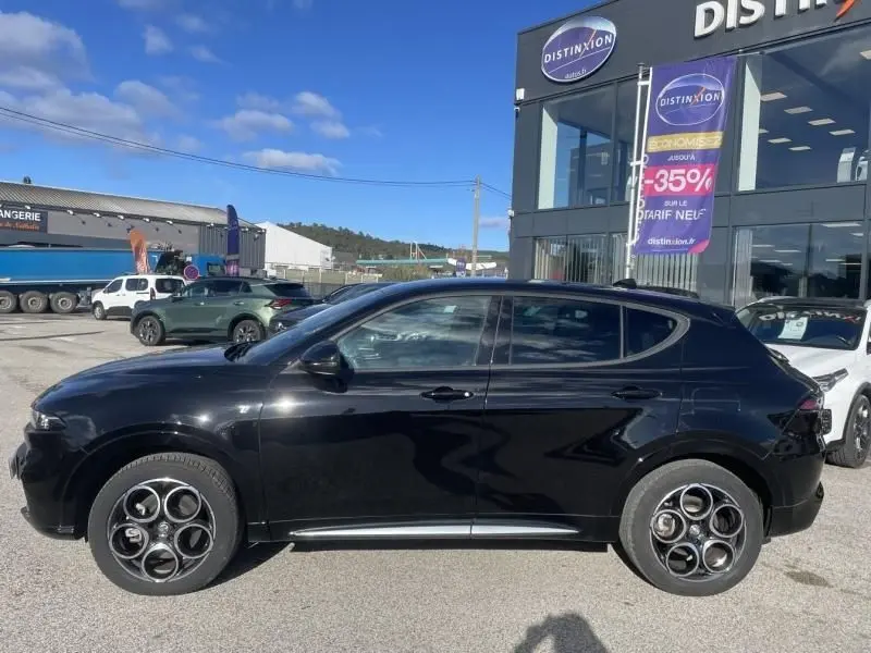 Profil côté gauche de l'Alfa Romeo Tonale noire 2023 hybride rechargeable, avec ses jantes distinctives à cinq cercles.